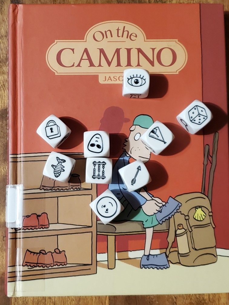 Story cubes roll on top of "On the Camino" by Jason